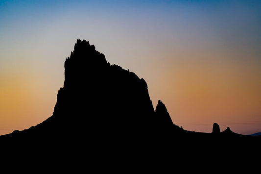 A large monadnock, silhouetted against a sunset sky in New Mexico 